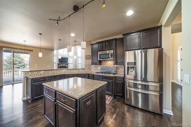 kitchen featuring a center island, hanging light fixtures, rail lighting, kitchen peninsula, and stainless steel appliances