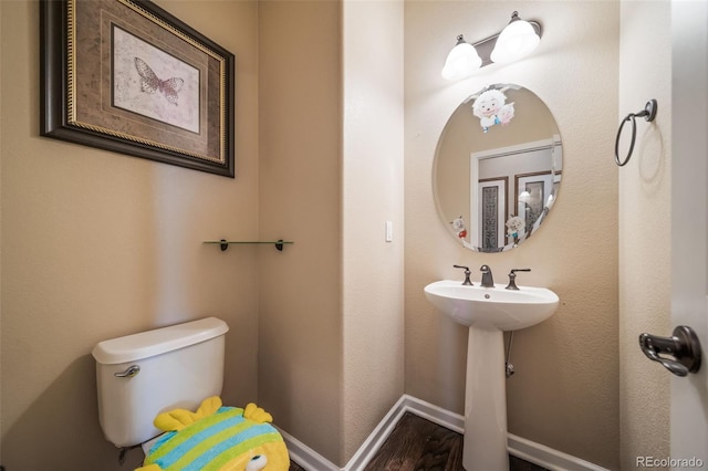 bathroom featuring hardwood / wood-style flooring and toilet