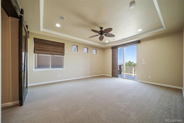 unfurnished room featuring carpet floors, ceiling fan, and a tray ceiling