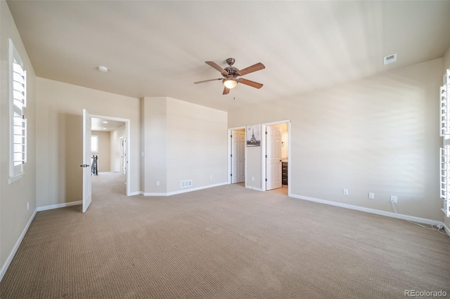 carpeted spare room featuring ceiling fan