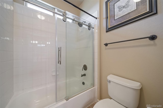 bathroom featuring enclosed tub / shower combo and toilet