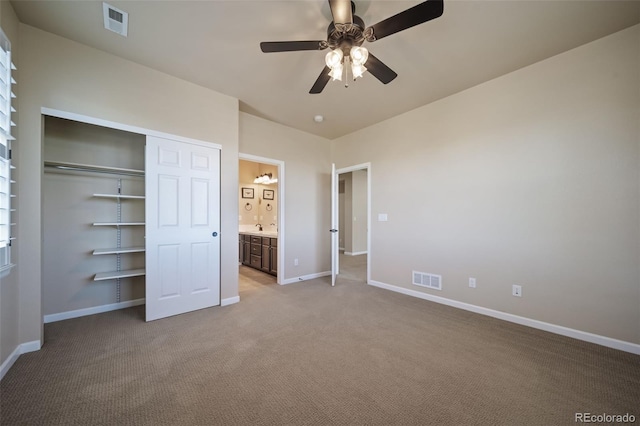 unfurnished bedroom with carpet flooring, a closet, ceiling fan, and sink