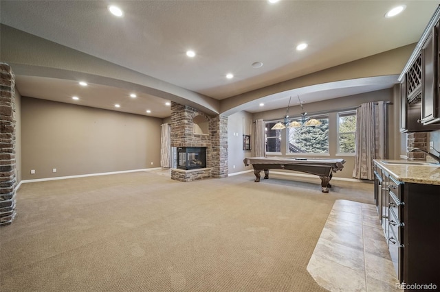 interior space with pool table, brick wall, light carpet, a fireplace, and sink