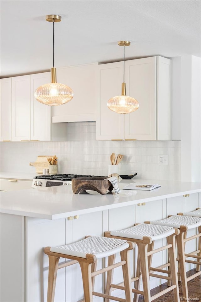 1695 E Eastman Ave, Englewood, CO 80113 - kitchen with decorative backsplash, a breakfast bar area, and white cabinetry