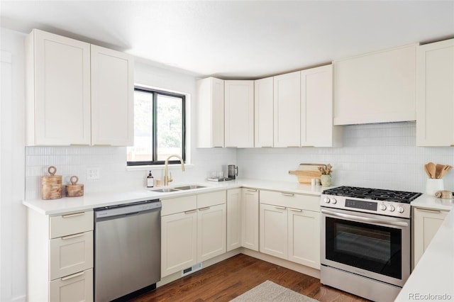 1695 E Eastman Ave, Englewood, CO 80113 - kitchen with appliances with stainless steel finishes, a sink, decorative backsplash, dark wood-style flooring, and light countertops