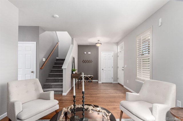 sitting room featuring stairway, wood finished floors, and baseboards