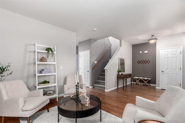 living area featuring stairs, wood finished floors, and baseboards