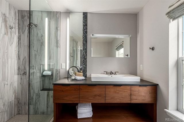full bathroom featuring a marble finish shower and vanity