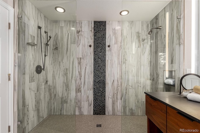 full bathroom featuring a marble finish shower and vanity