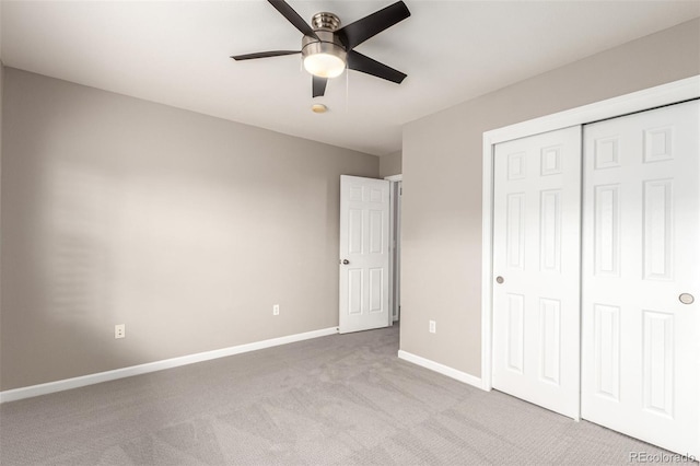 unfurnished bedroom with carpet flooring, baseboards, a closet, and a ceiling fan
