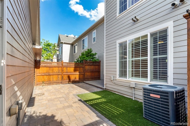 view of patio / terrace featuring central air condition unit and fence