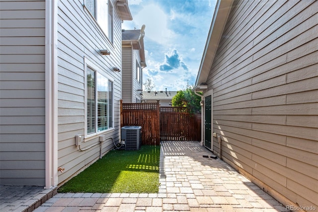 view of side of property with central AC unit, fence, and a gate