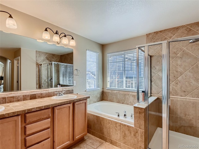 bathroom with tile patterned floors, vanity, a textured ceiling, and shower with separate bathtub