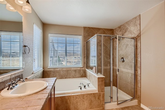 bathroom with tile patterned floors, plus walk in shower, sink, and a wealth of natural light