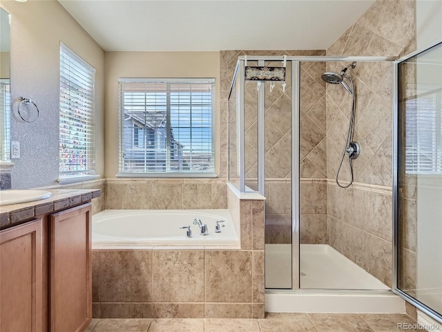 bathroom featuring plus walk in shower, vanity, and tile patterned floors