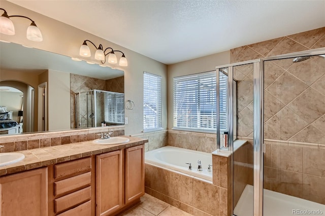 bathroom with vanity, tile patterned flooring, and plus walk in shower