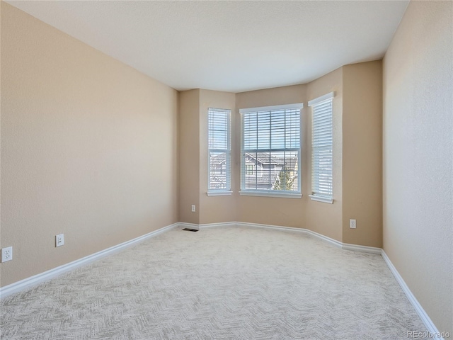 spare room featuring light carpet