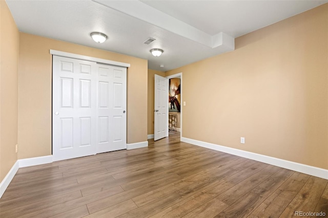 unfurnished bedroom featuring hardwood / wood-style flooring and a closet