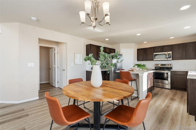 dining space featuring light hardwood / wood-style flooring and a chandelier