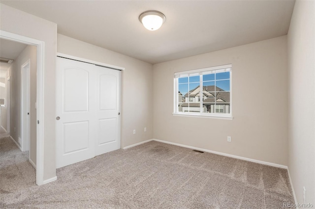 unfurnished bedroom with a closet and light carpet