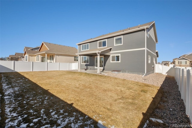 rear view of property featuring a patio area and a lawn