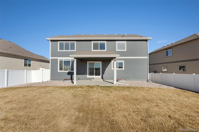 back of house with a patio area and a yard