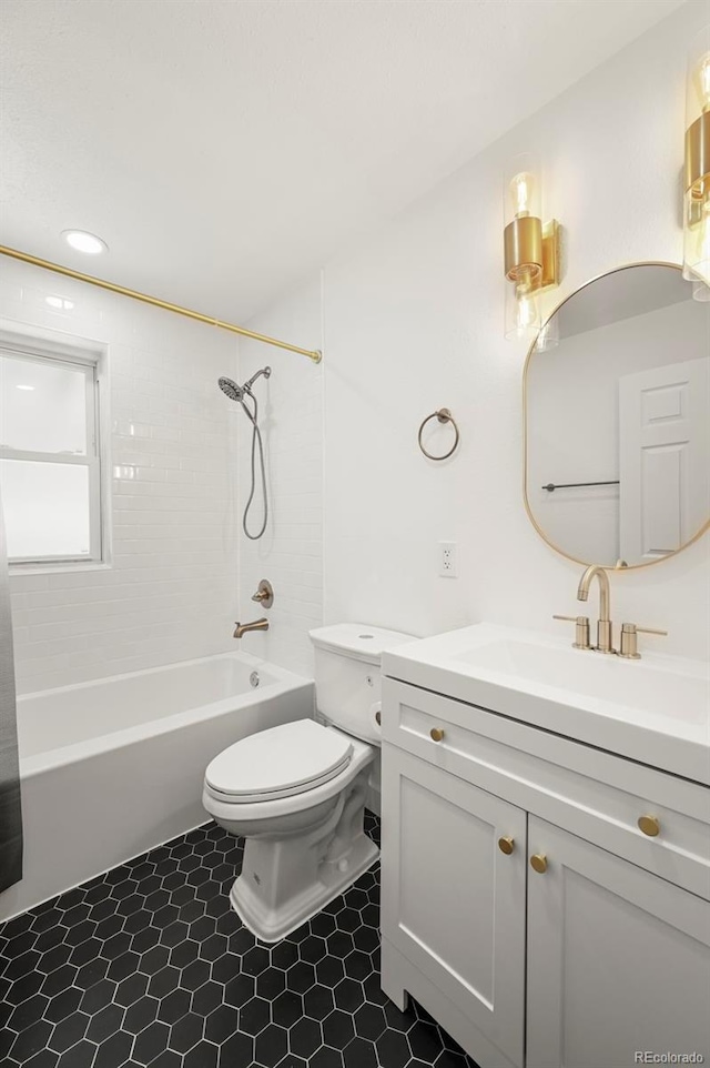 full bathroom featuring vanity, tiled shower / bath combo, and toilet