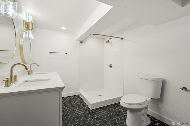 bathroom featuring toilet, a tile shower, and vanity