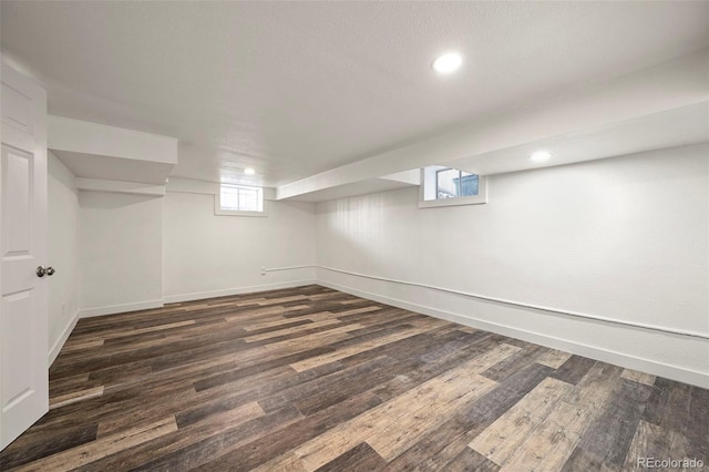 basement with dark hardwood / wood-style floors