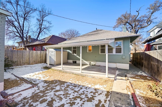 rear view of property with a patio area and a storage unit