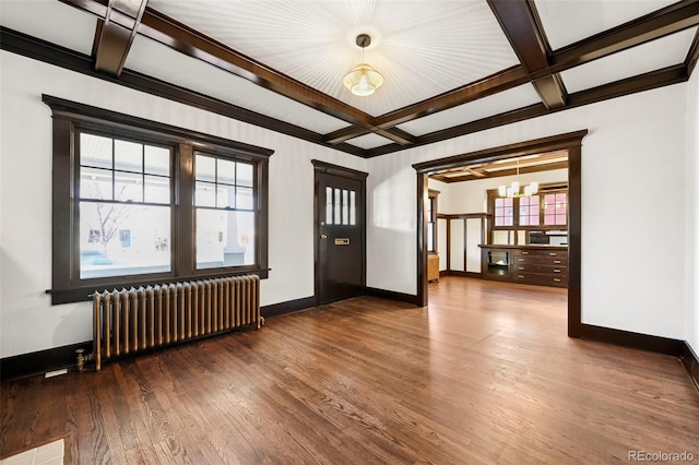 empty room featuring coffered ceiling, radiator heating unit, a chandelier, and hardwood / wood-style flooring