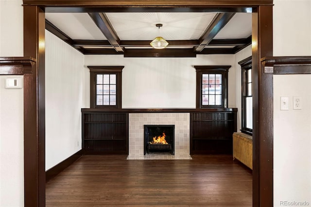 unfurnished living room featuring coffered ceiling, beam ceiling, and a wealth of natural light