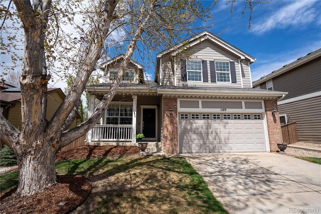 traditional-style home with a porch, brick siding, an attached garage, and driveway