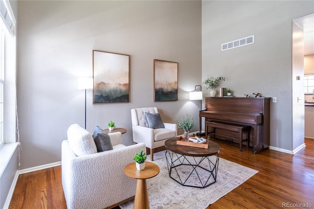 living area featuring visible vents, baseboards, and wood finished floors
