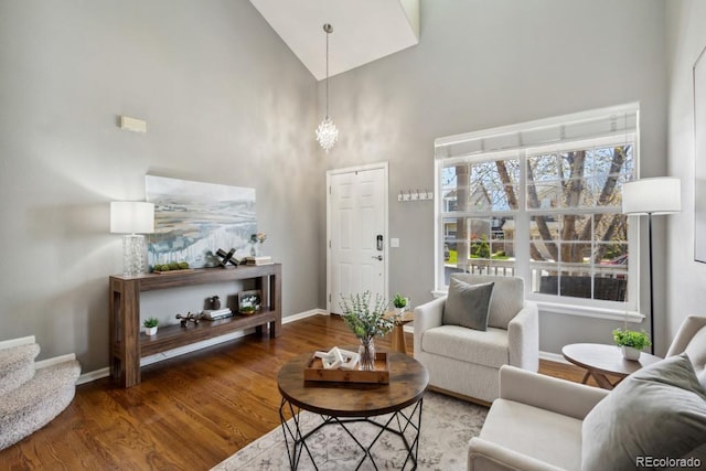 living room with baseboards, a high ceiling, stairs, and wood finished floors
