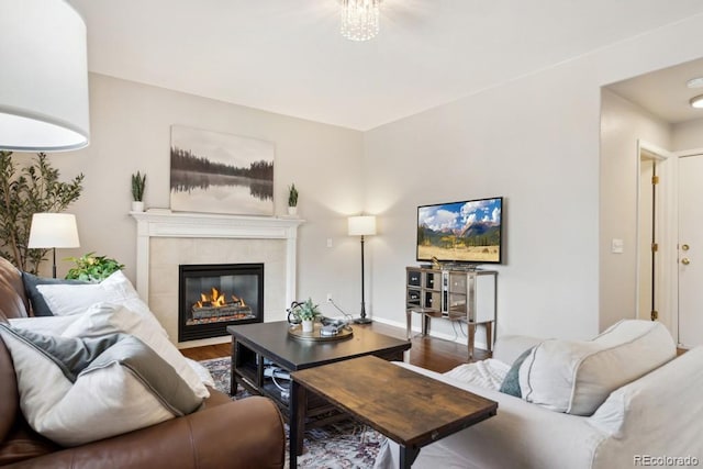 living room with a tile fireplace and wood finished floors