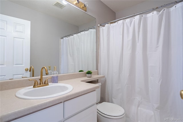 bathroom with toilet, visible vents, and vanity