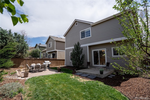 back of house featuring fence, a yard, and a patio area