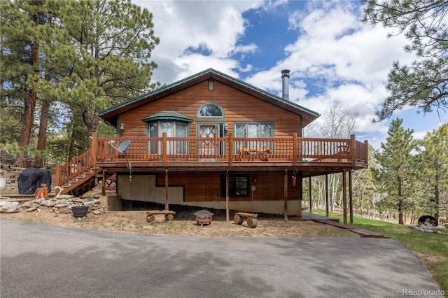 view of front facade with a deck, stairway, and driveway