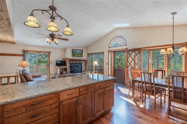 kitchen with ceiling fan, a textured ceiling, vaulted ceiling, dark wood-style floors, and a chandelier