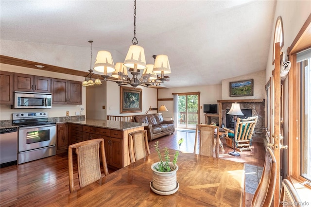 dining space featuring a chandelier, dark wood-style floors, and a fireplace