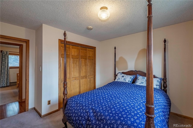 carpeted bedroom with a closet, baseboards, and a textured ceiling