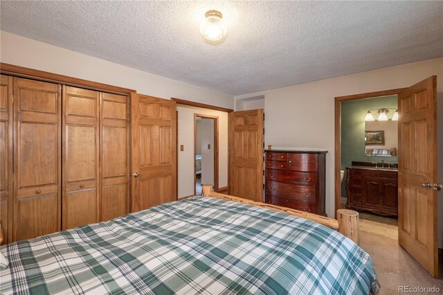 bedroom featuring a textured ceiling, a sink, light carpet, and a closet