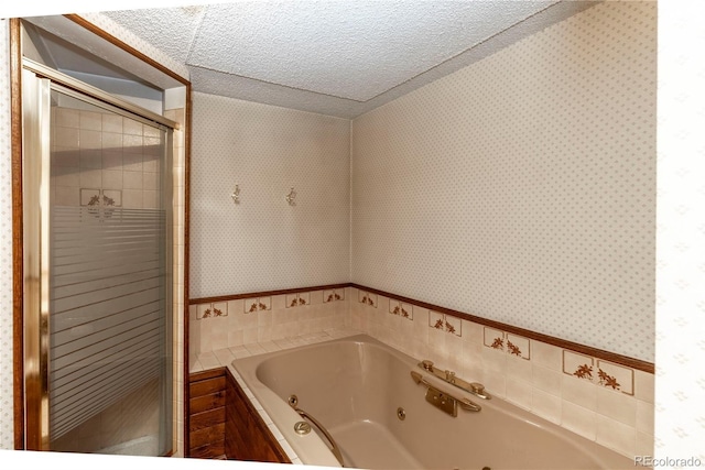 bathroom featuring wallpapered walls, a stall shower, a jetted tub, a textured ceiling, and tile walls