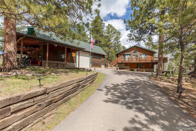 view of front of property with asphalt driveway and a deck
