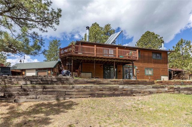 rear view of property featuring a deck and a yard