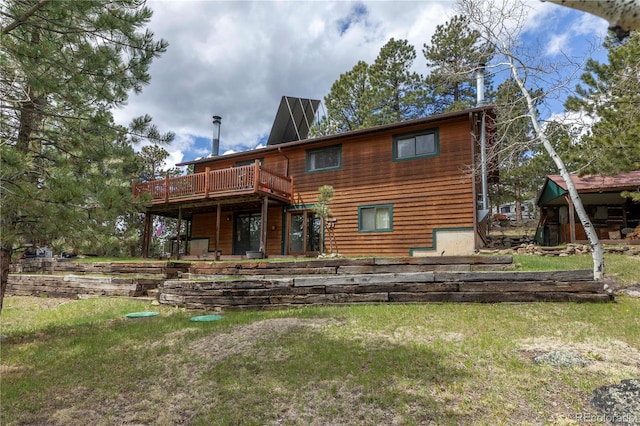 rear view of property featuring a deck and a yard