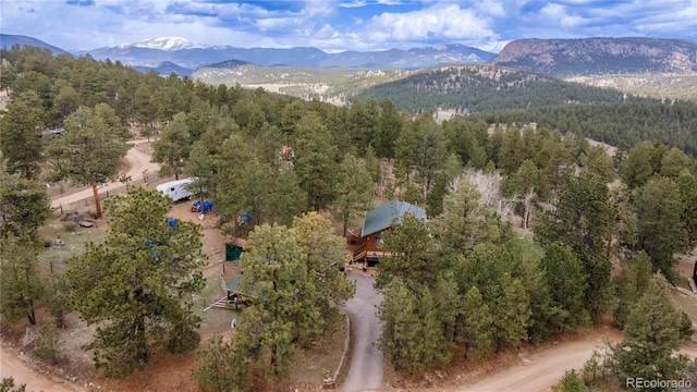 aerial overview of property's location featuring mountains and a forest
