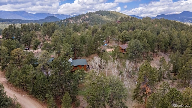 aerial overview of property's location featuring a mountainous background and a forest