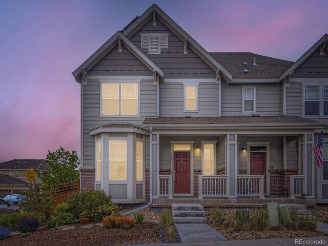 3921 E 141st Ave, Thornton, CO 80602 - townhome / multi-family property with covered porch, brick siding, and roof with shingles
